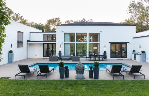 Pool outside of a luxury home with tall windows