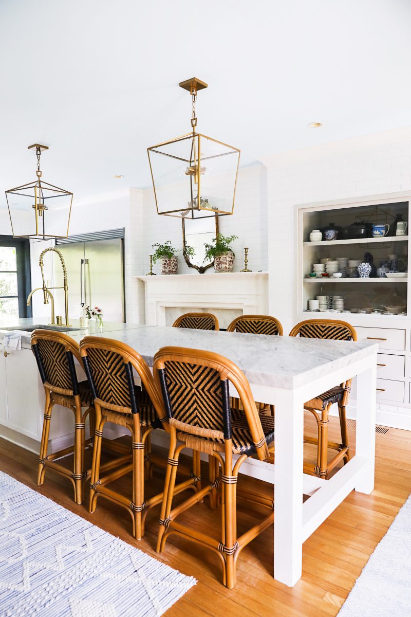 white aesthetic kitchen with gold and bronze accents and wicker chairs