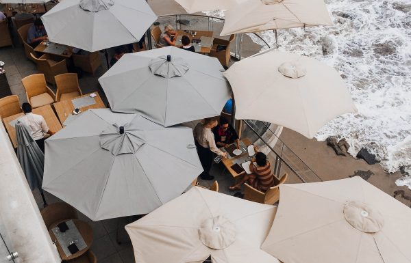 Shaded umbrella patio on a rocky beach, featured in the Nashville Edit.